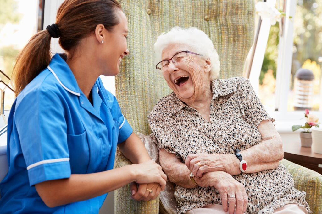 Elderly lady laughing with nurse
