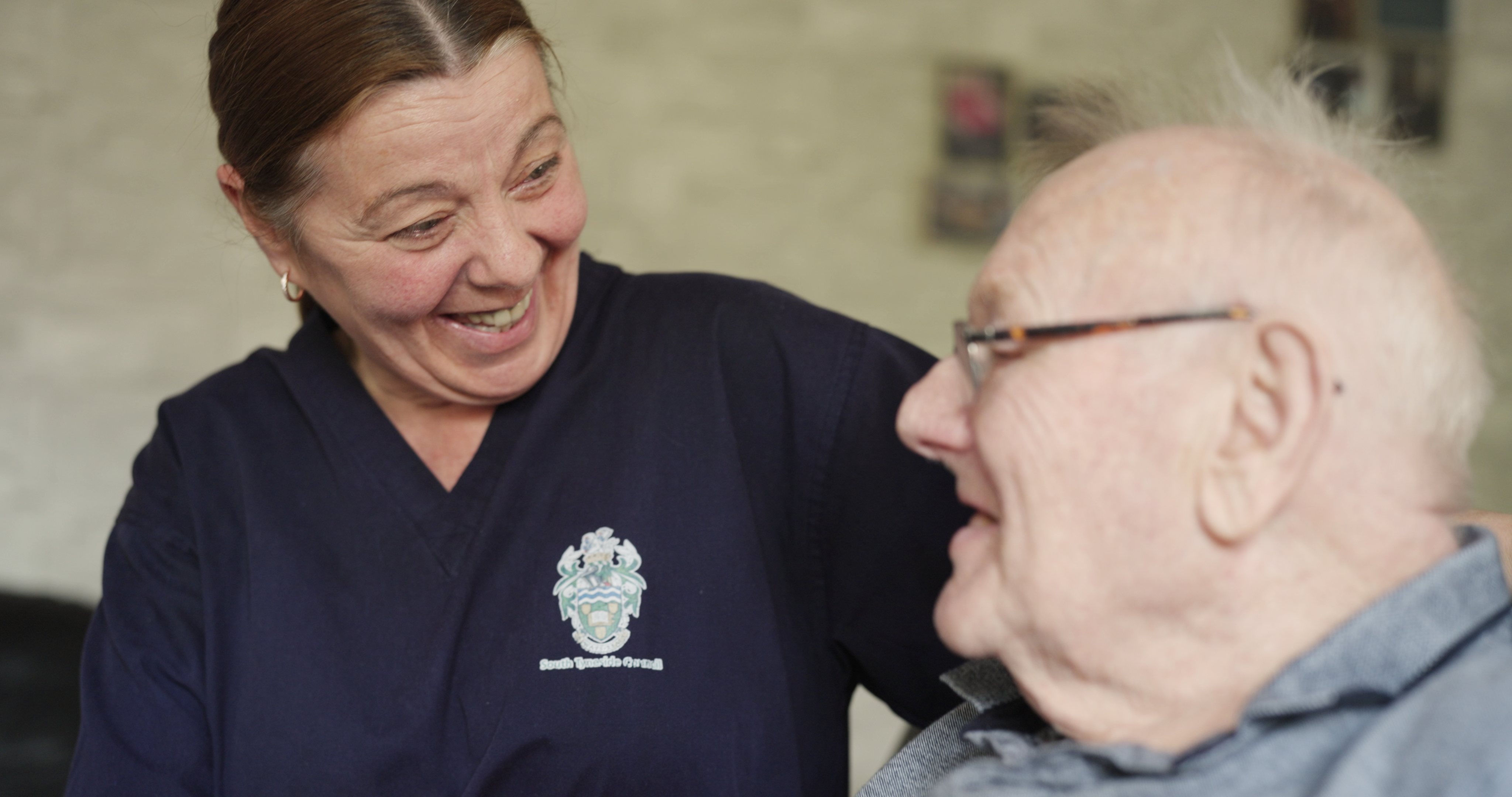 A photo of an extra care support worker with a man she supports.